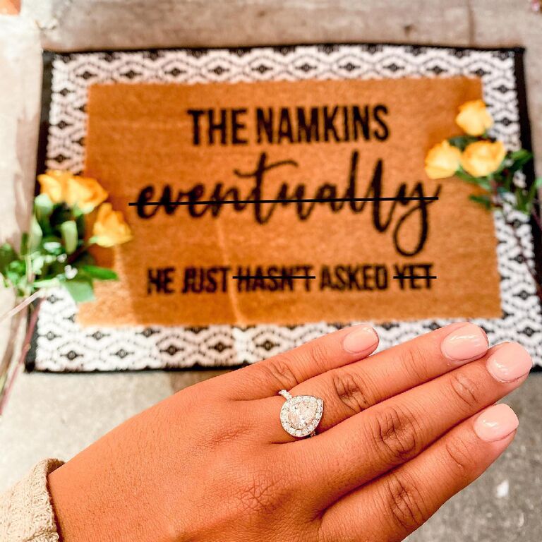 Engagement ring selfie above custom last name doormat
