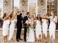 Wedding pary throwing confetti around bride and groom