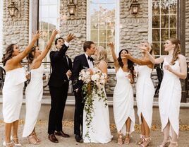 Wedding pary throwing confetti around bride and groom