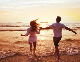 Couple holding hands on the beach