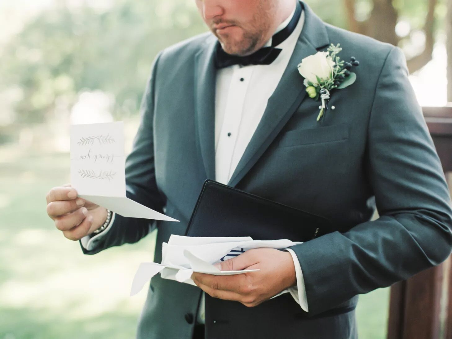 A groom reads a letter from their spouse on their wedding day.