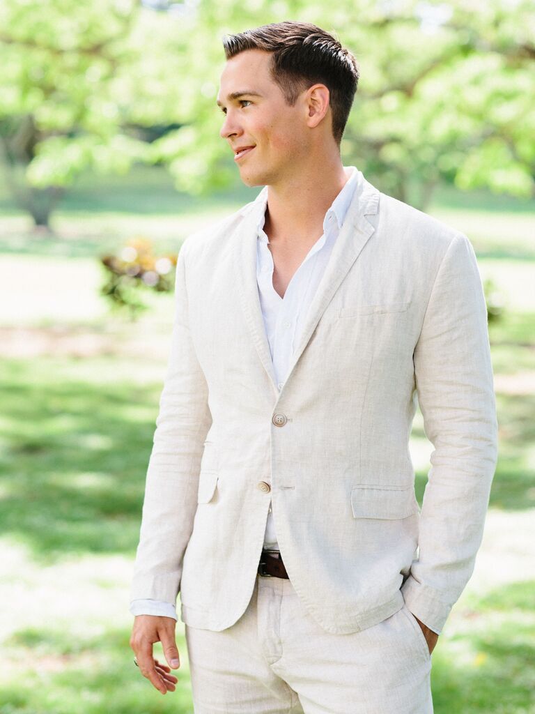 groom wearing ivory linen suit with white button down shirt