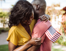 Couple hugging and holding small American flag on fourth of july