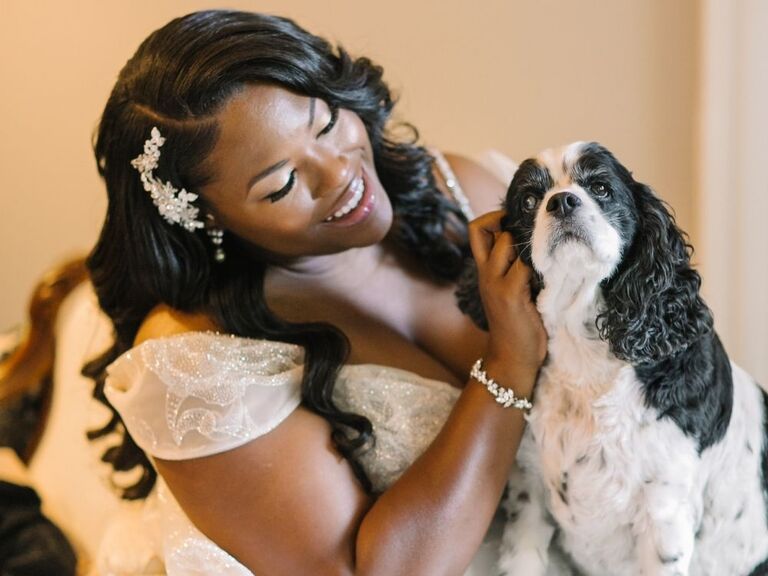 bride petting dog on wedding day