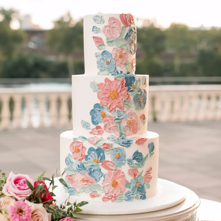 Pastel buttercream floral cake in pink, blue and white