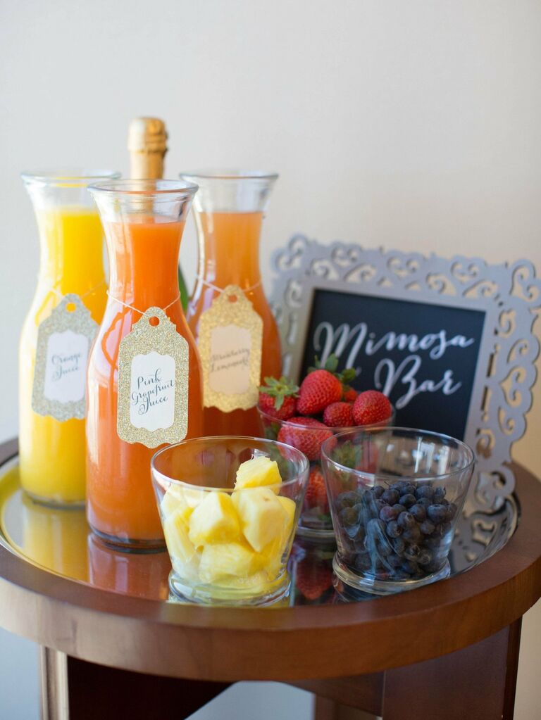 Mimosa bar featuring different juices and a selection of fresh fruit. 