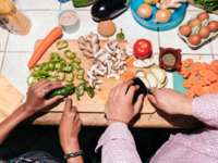 Couple chopping vegetables, grocery budget for two