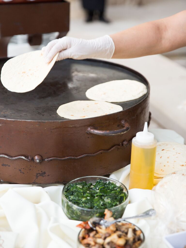 A chef makes homemade flour tortillas on a large griddle. 