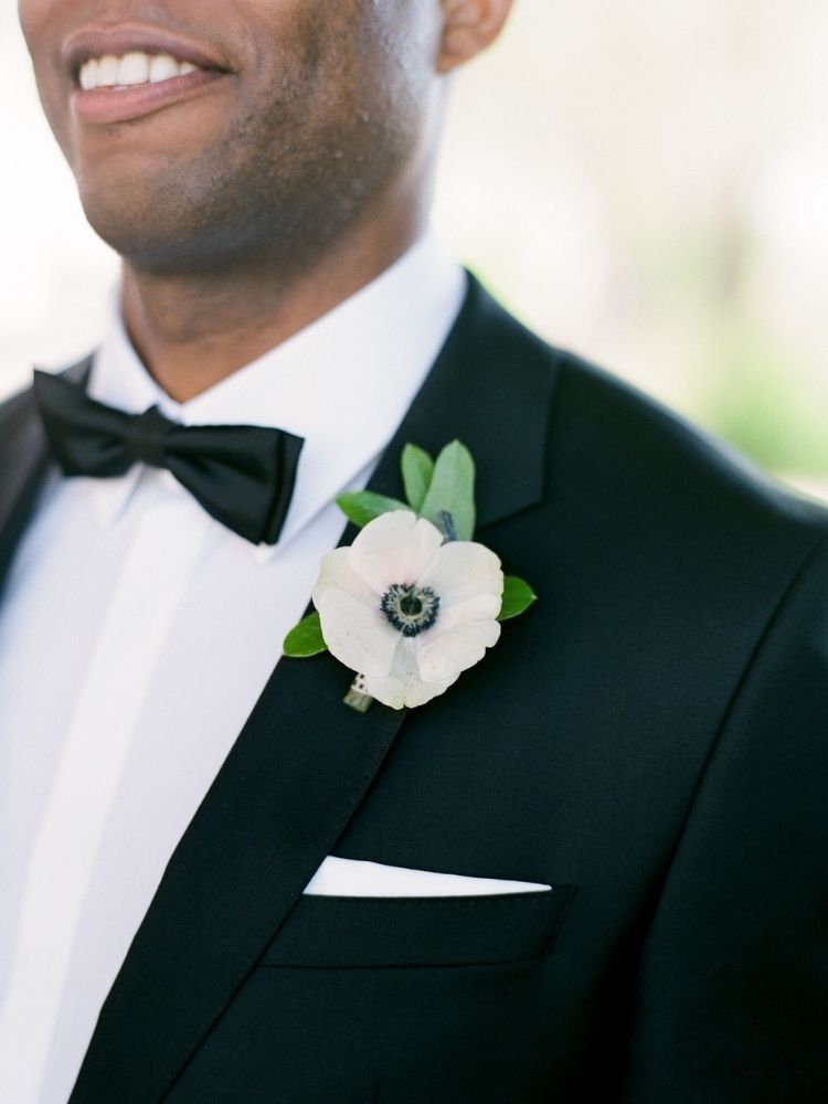 Groom wearing white anemone boutonniere