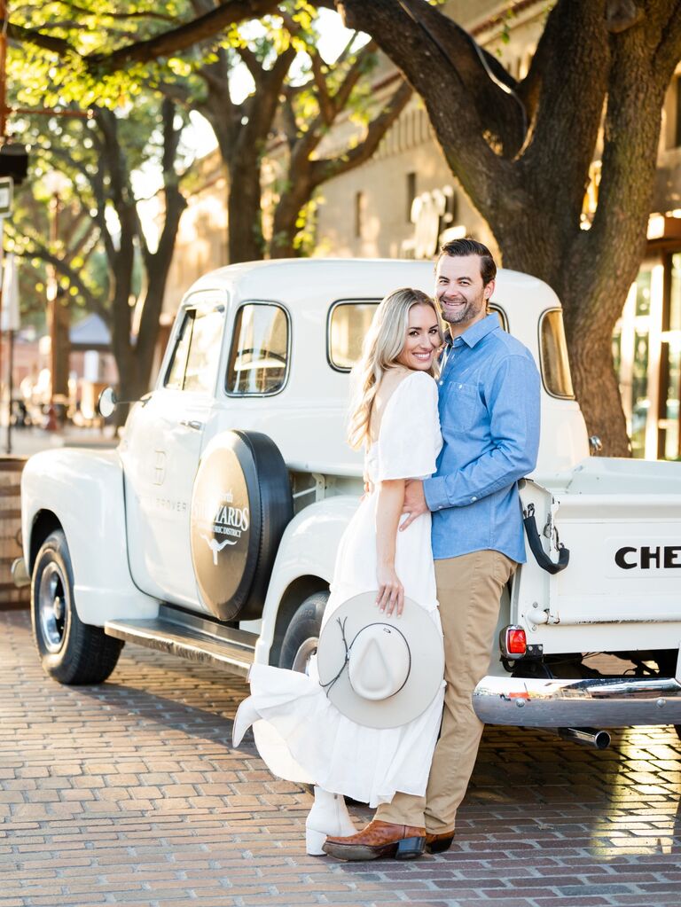 Couple pose in front of a retro truck. 