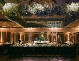 Wedding reception venue with moody uplighting and floating baby's breath floral installation