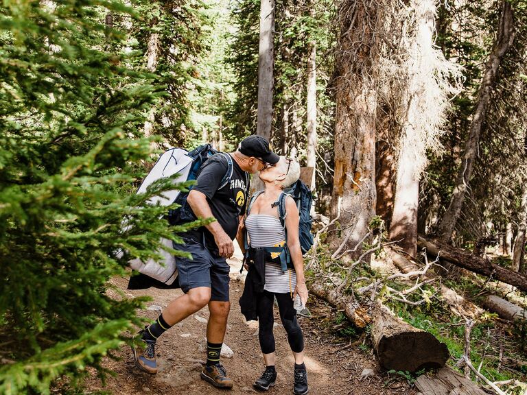 Couple on a hike pauses to share a sweet kiss. 