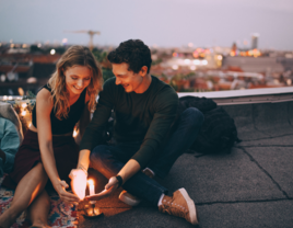 Twin flame couple sitting on rooftop with candle