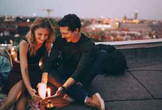 Twin flame couple sitting on rooftop with candle