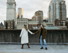 Couple's engagement photos on roof of parking garage with Boston skyline background