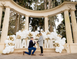 Man proposing to woman in front of 'Marry Me' sign in Orlando