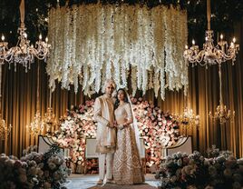 Happy couple posing for a portrait in their grand wedding reception venue