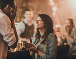 Woman proposing to man in public at a bar