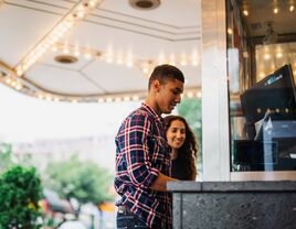 Happy couple buying movie tickets at the theater