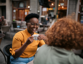 Sisters-in-law talking with each other over coffee