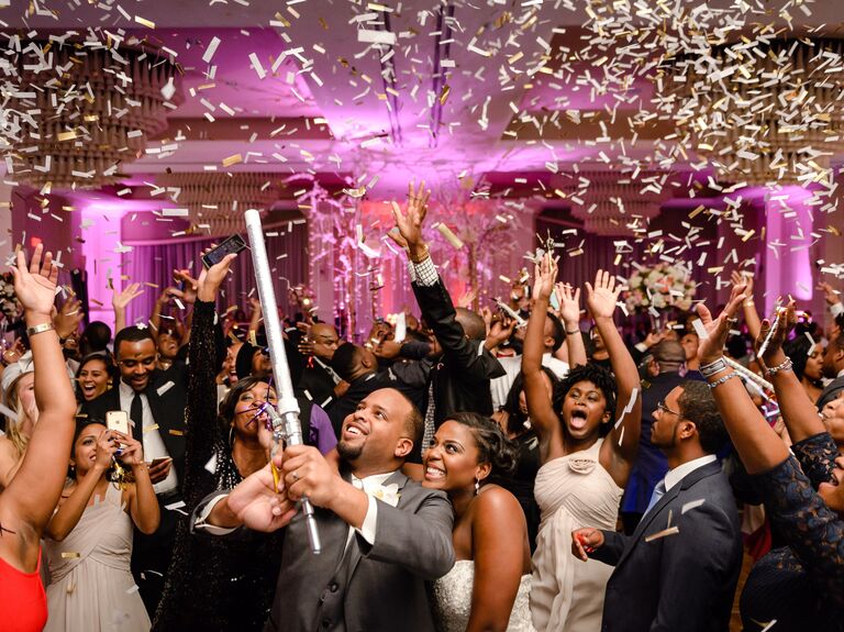 Couple and guests have fun with confetti at wedding reception.