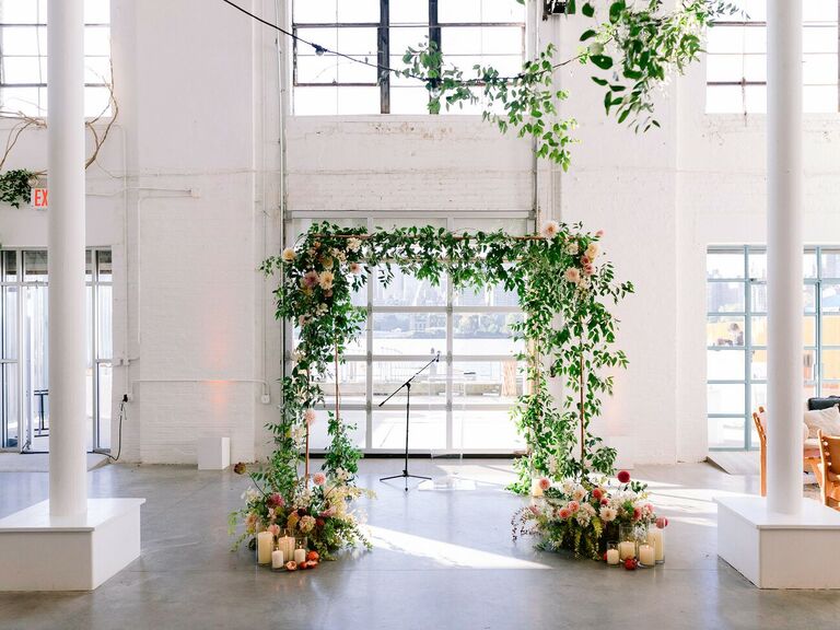 Greenery ceremony arch in white loft venue