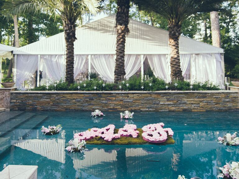 Outdoor wedding with floating floral monogram in pool