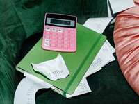 Pink calculate on a green folder with receipts