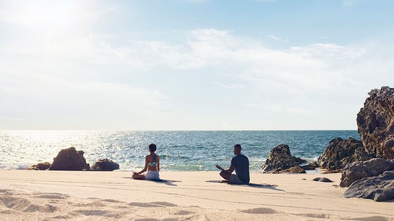 couple meditating on the beach pacific coast four seasons punta mita 