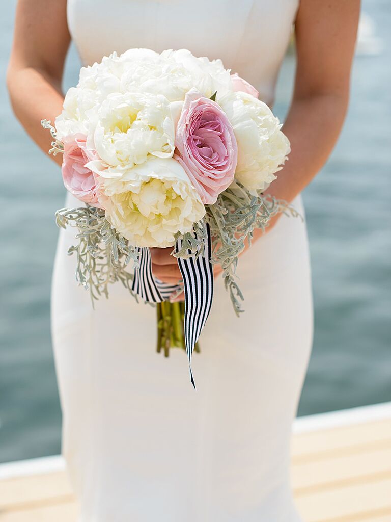 White and pink wedding bouquet wrapped with striped ribbon