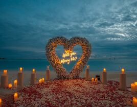 Romantic beach proposal with rose petals and candles