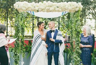 Couple under chuppah at Jewish wedding ceremony