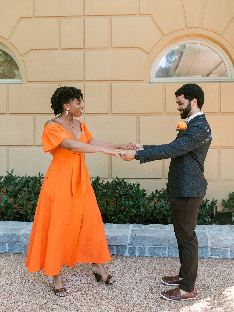 Bride wearing vibrant orange tea-length wedding dress