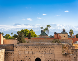 Walls of El Badi Palace with mountains in background in Marrakech, Morocco