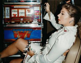 Bride playing slot machine in short white wedding dress