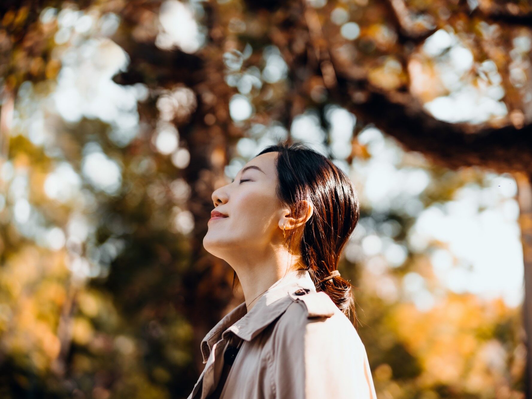 Woman smiles to herself while enjoying a walk on a beautiful autumn day. 