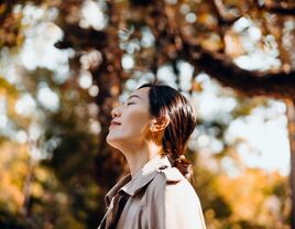 Woman smiles to herself while enjoying a walk on a beautiful autumn day. 