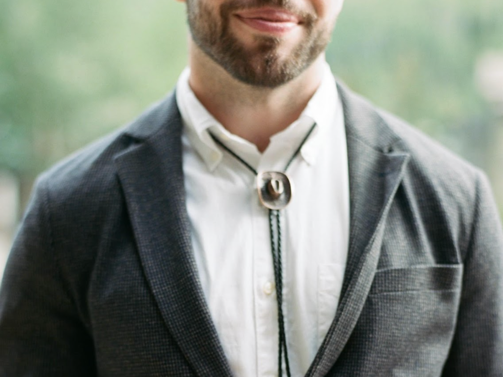 Man wearing cowboy hat bolo tie at wedding