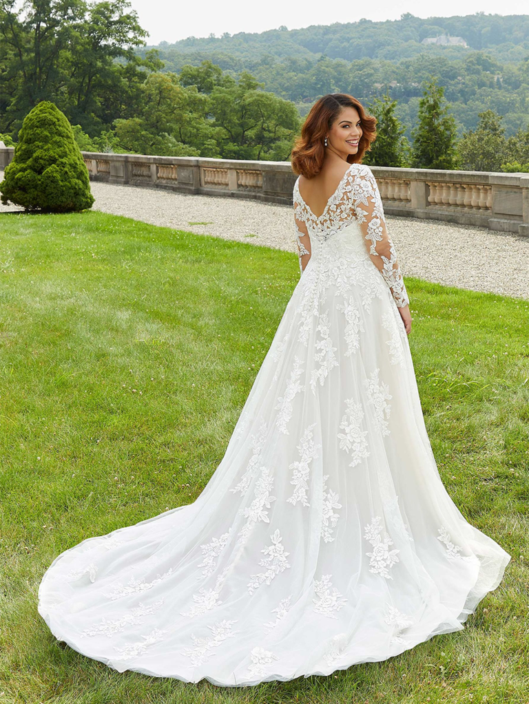 Cape sleeved wedding dress with illusion neckline and floral appliqué  across the bodice