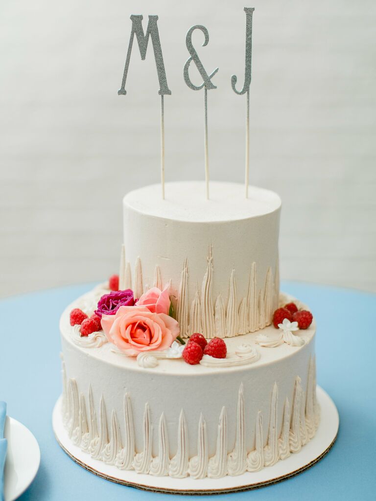 two tier wedding cake decorated with buttercream piping and M & J initials cake topper