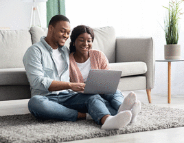 Couple similing while looking at a computer.