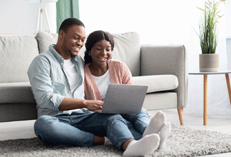Couple similing while looking at a computer.