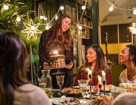 Women sitting at table enjoying cake at bachelorette party