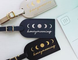 Black, blue and white leather tags with 'honeymooning' in gold or silver script and moon phase graphics