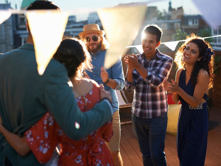 Friends celebrating proposal on rooftop