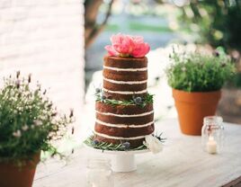 two tier chocolate naked wedding cake with bright pink peonies on top