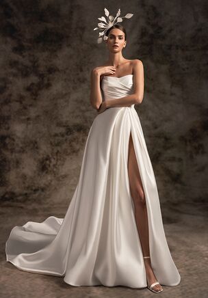 An absolutely showstopping sheer satin wedding dress with asymmetric sweetheart strapless corset. A draped skirt with a thigh-high slit proceeds into a dramatic, pointed cathedral-length train for a really memorable moment.