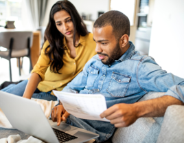 Couple looking at laptop creating wedding financial plan