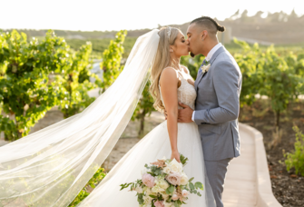 bride and groom kissing in a vineyard