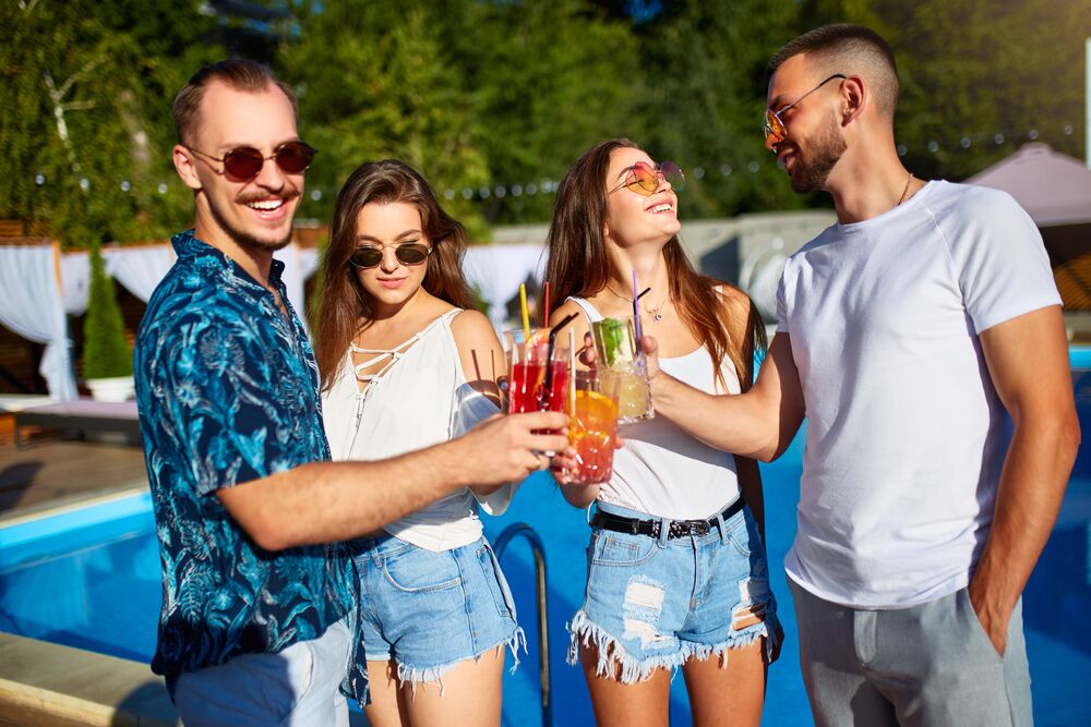 group of adults drinking near a pool